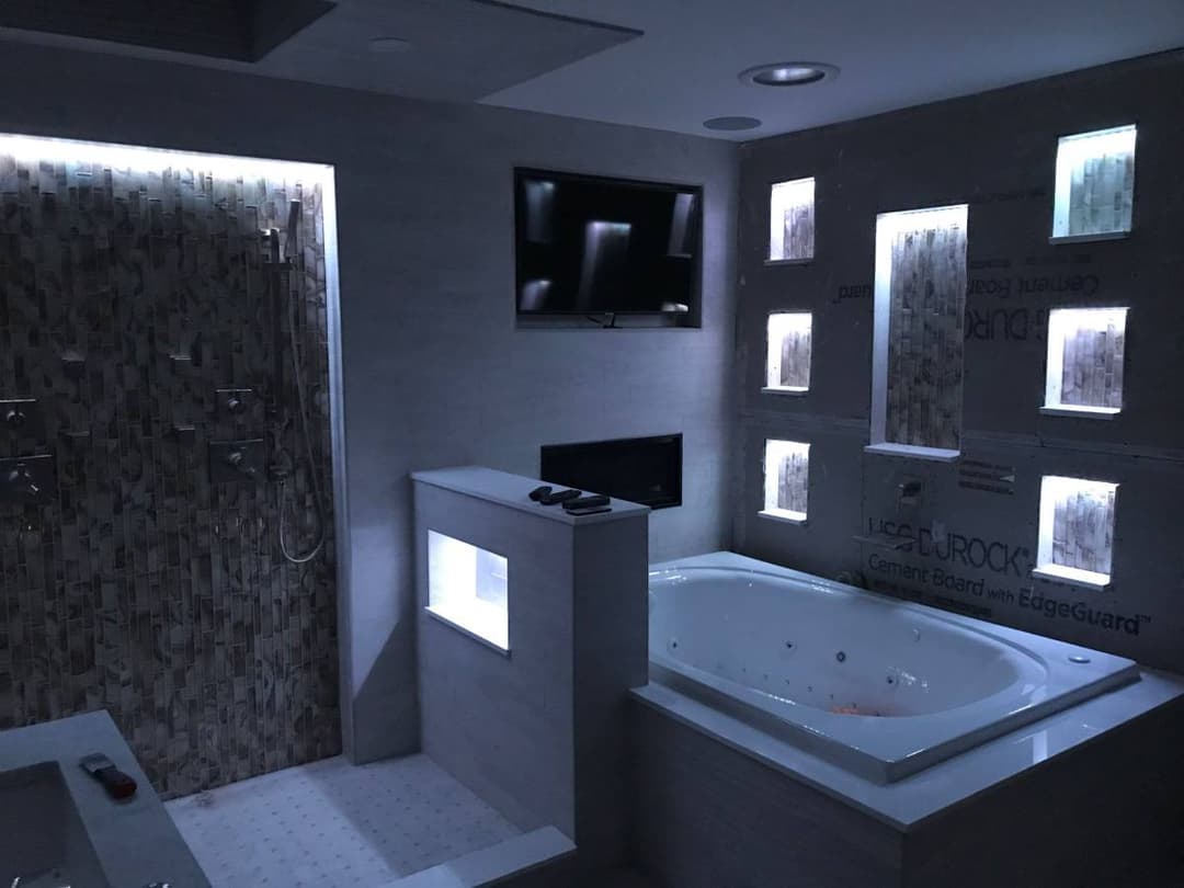 picture of newly remodeled bathroom with recessed walls and lighting and new bathtub